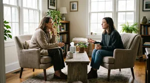Dos personas conversan frente a frente con una taza de té